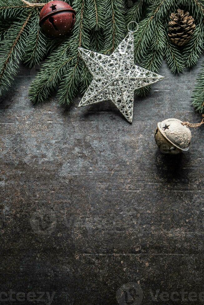 Top of view christmas star decorations jingle bells fir tree pine cones on free concrete background photo
