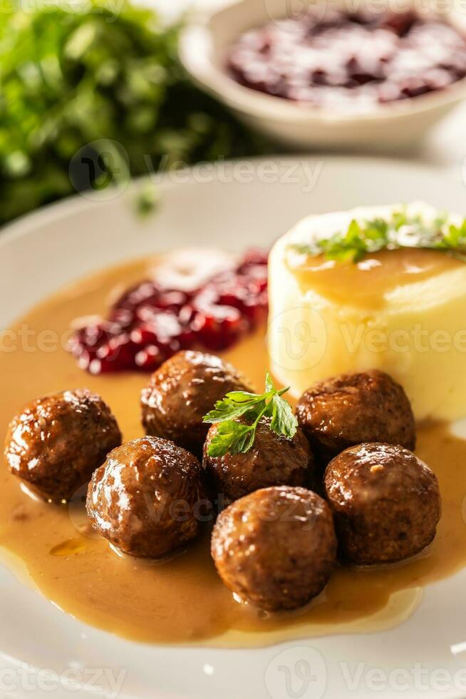 Plate serving Swedish meatballs kottbullar in sauce with mashed potatoes and cranberry sauce photo