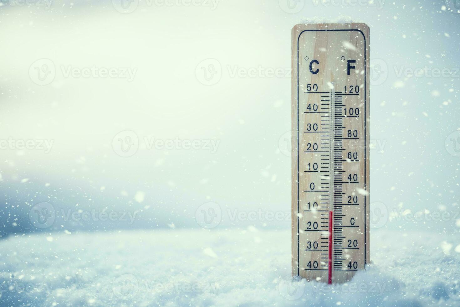 Thermometer on snow shows low temperatures under zero. Low temperatures in degrees Celsius and fahrenheit. Cold winter weather ten under zero. photo