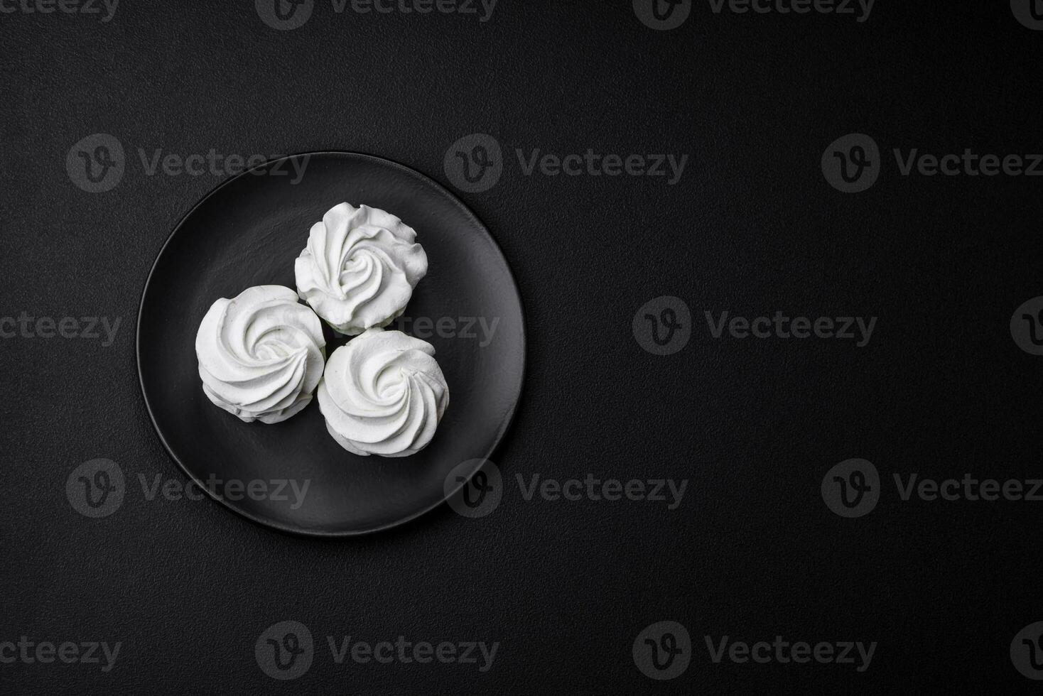 Delicious sweet colored marshmallow on a dark concrete background photo