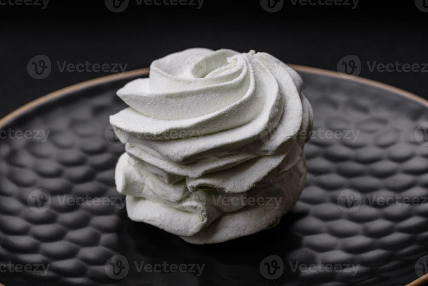 Delicious sweet colored marshmallow on a dark concrete background photo