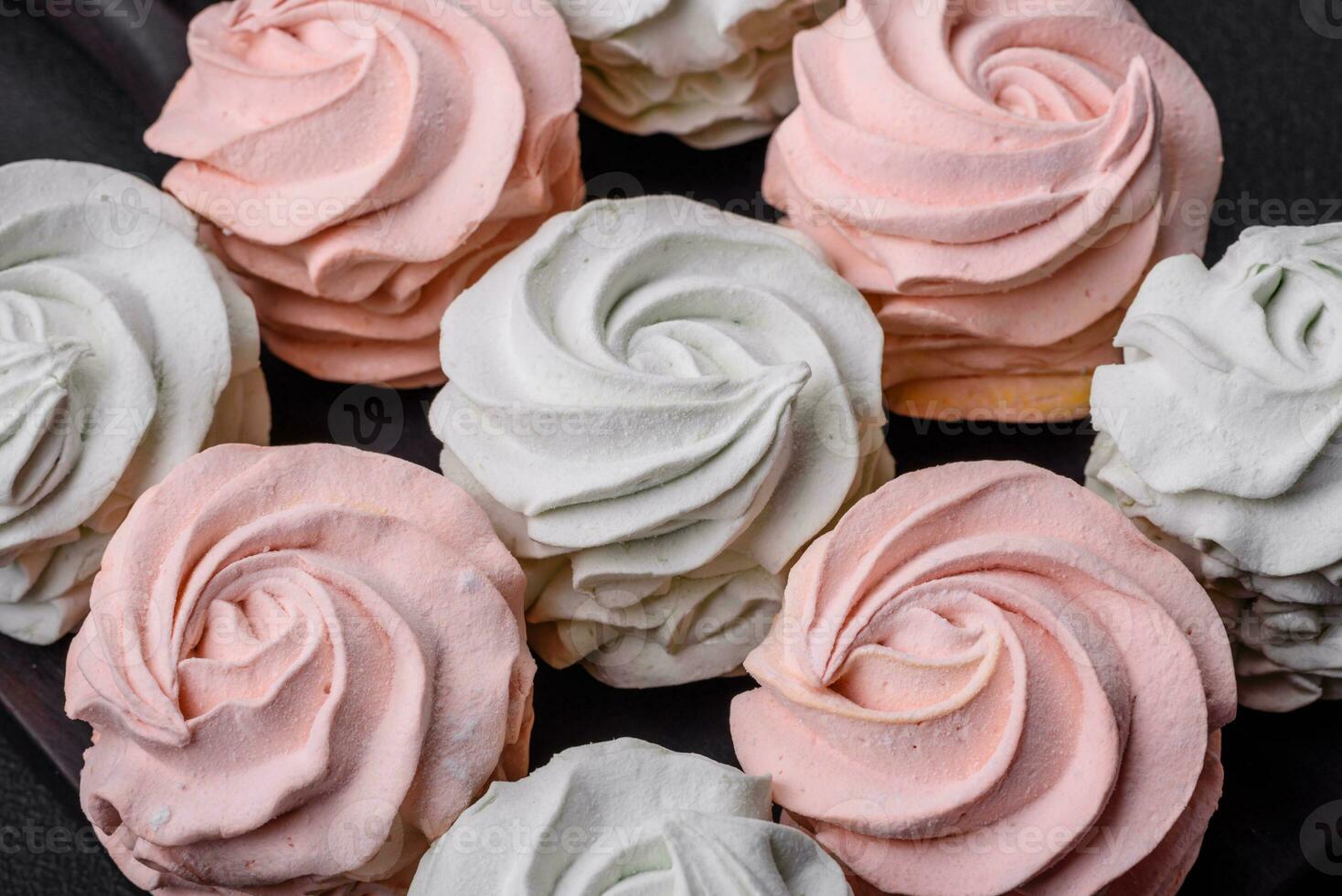 Delicious sweet multi-colored marshmallow on a dark concrete background photo
