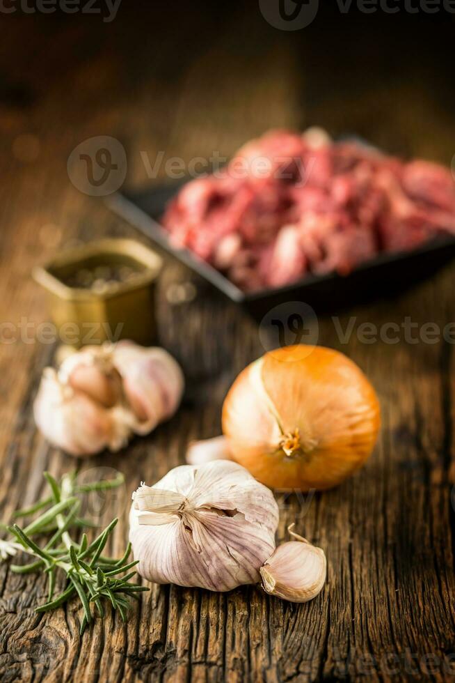 Garlic. Garlic onion rosemary and raw beef meat in the background photo