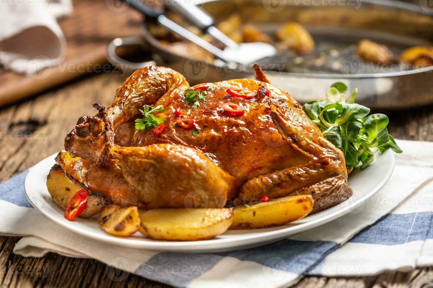 Roasted chicken and american potatoes with chili peppers and herbs photo