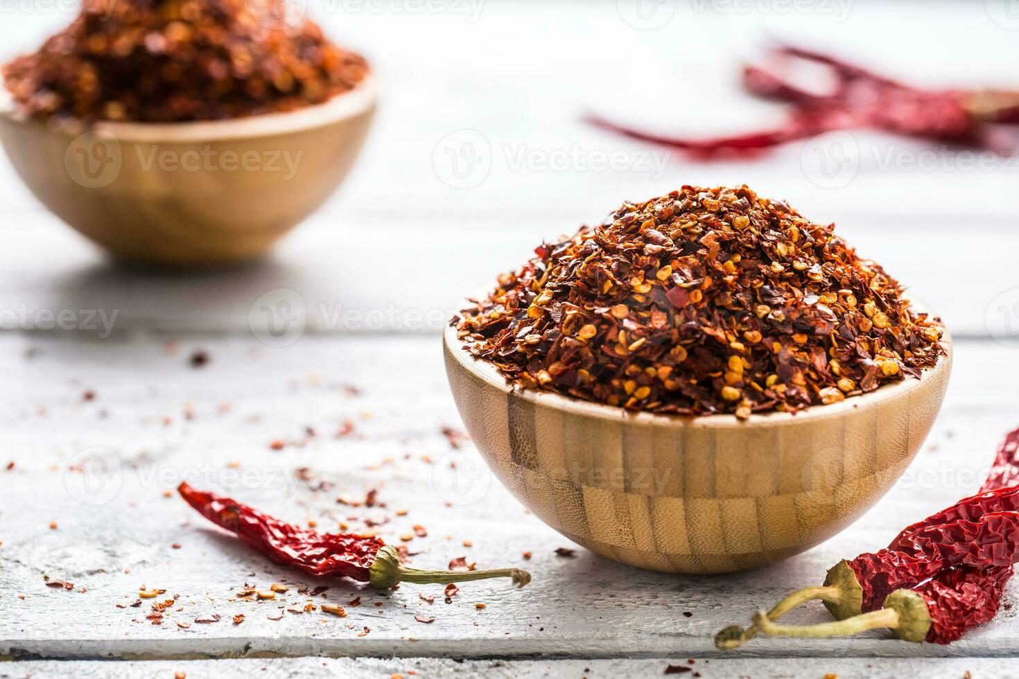 Dried and crushed chili peppers in wooden bowles photo