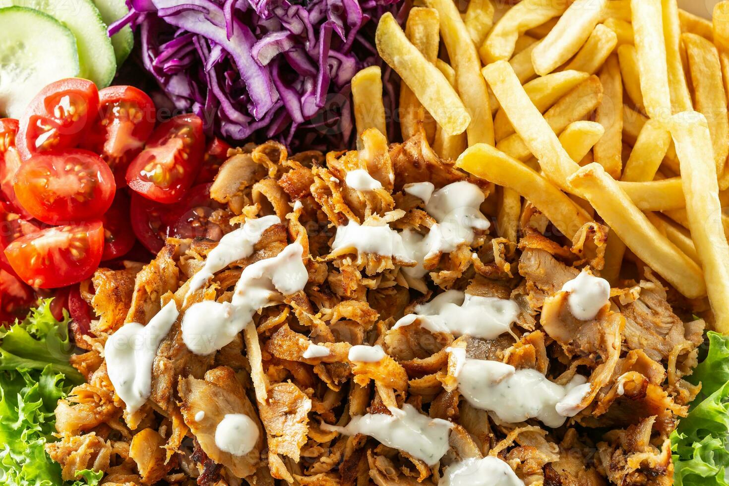 Top view closeup of Turkish grilled kebab with homegrown vegetables, salty fries and tasty dressing photo