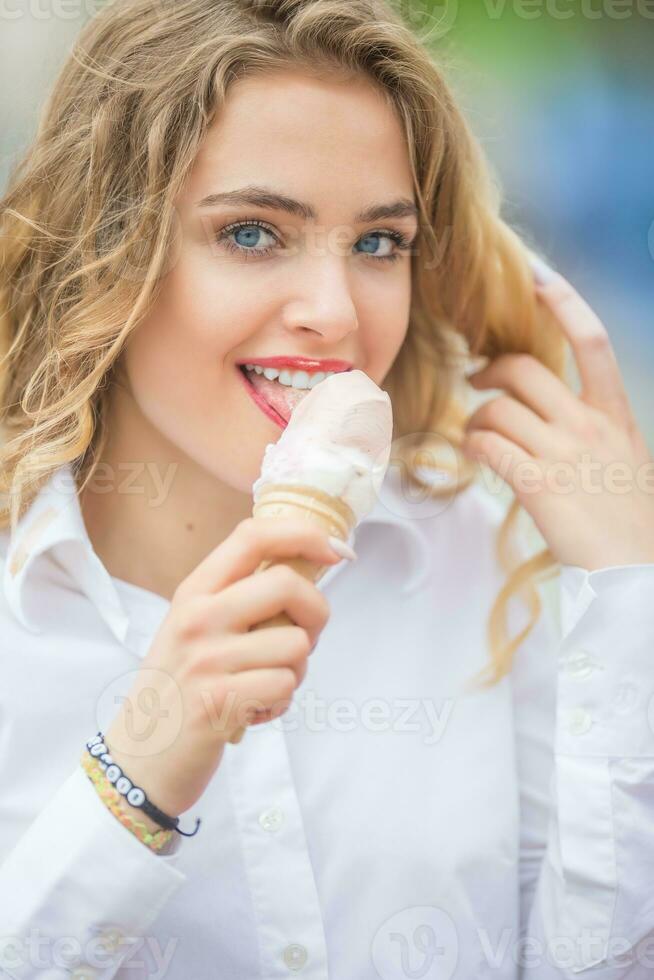 Young blonde teen girl eating sweet ice cream photo