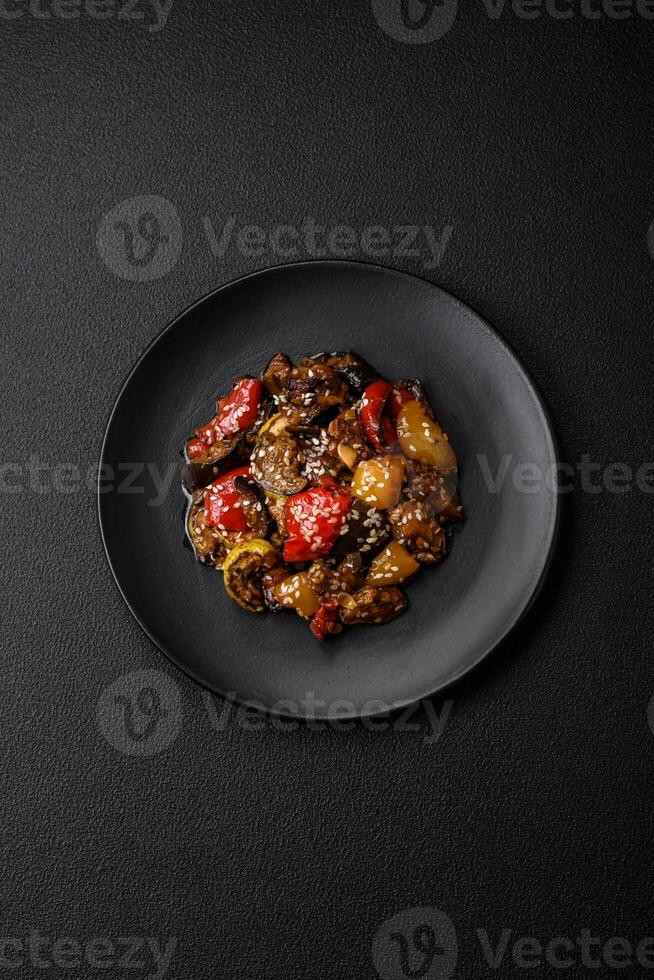 Delicious juicy fresh salad of baked eggplant, tomatoes, sweet peppers, sesame seeds photo