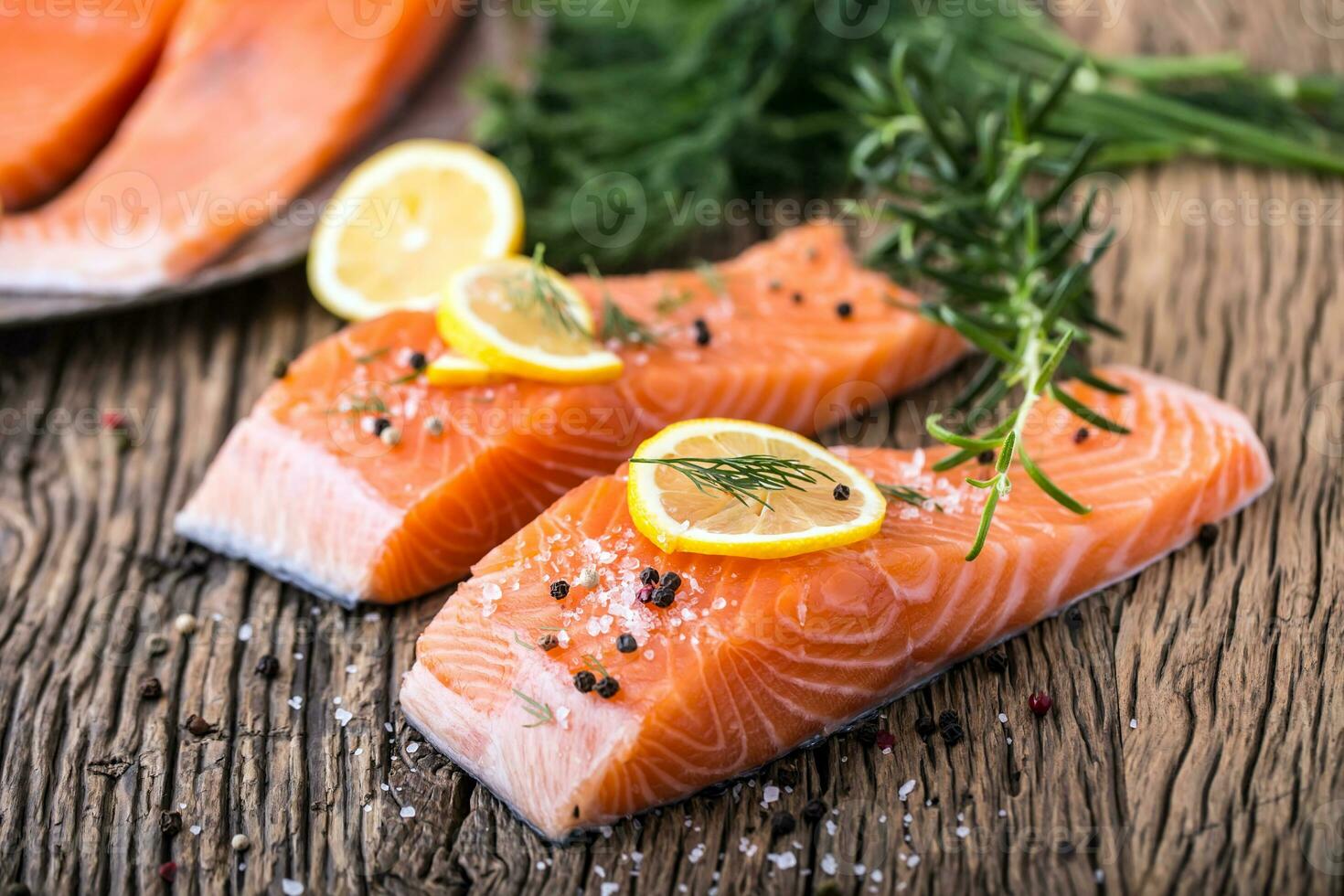 salmón pescado crudo salmón filete pimienta sal eneldo limón Romero en de madera mesa. foto