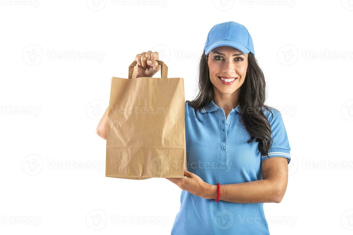 Beautiful delivery woman in an uniform holding a takeaway paper bag waiting for her customer. Isolated background photo