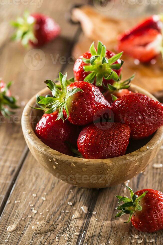 jugoso lavado fresas en de madera cuenco en cocina mesa foto