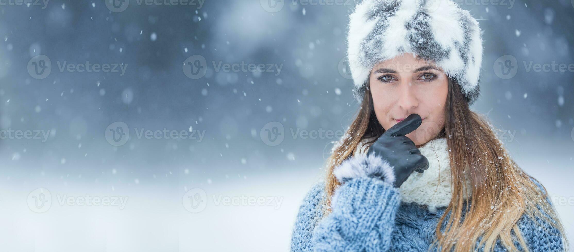 Portrait of young beautiful woman in winter clothes and strong snowing. photo