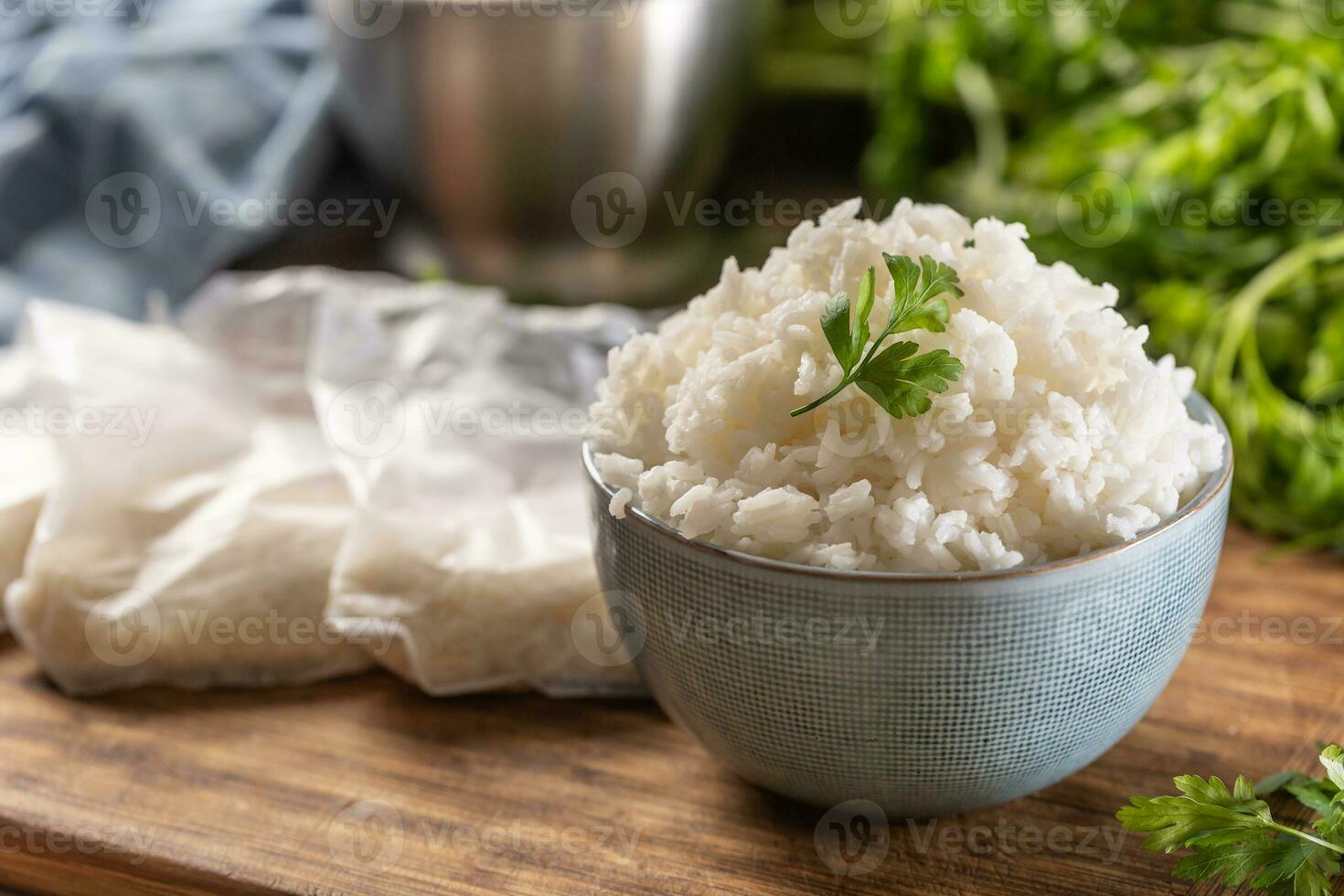 Cooked rice in a bowl with raw rice in plastick bags. photo