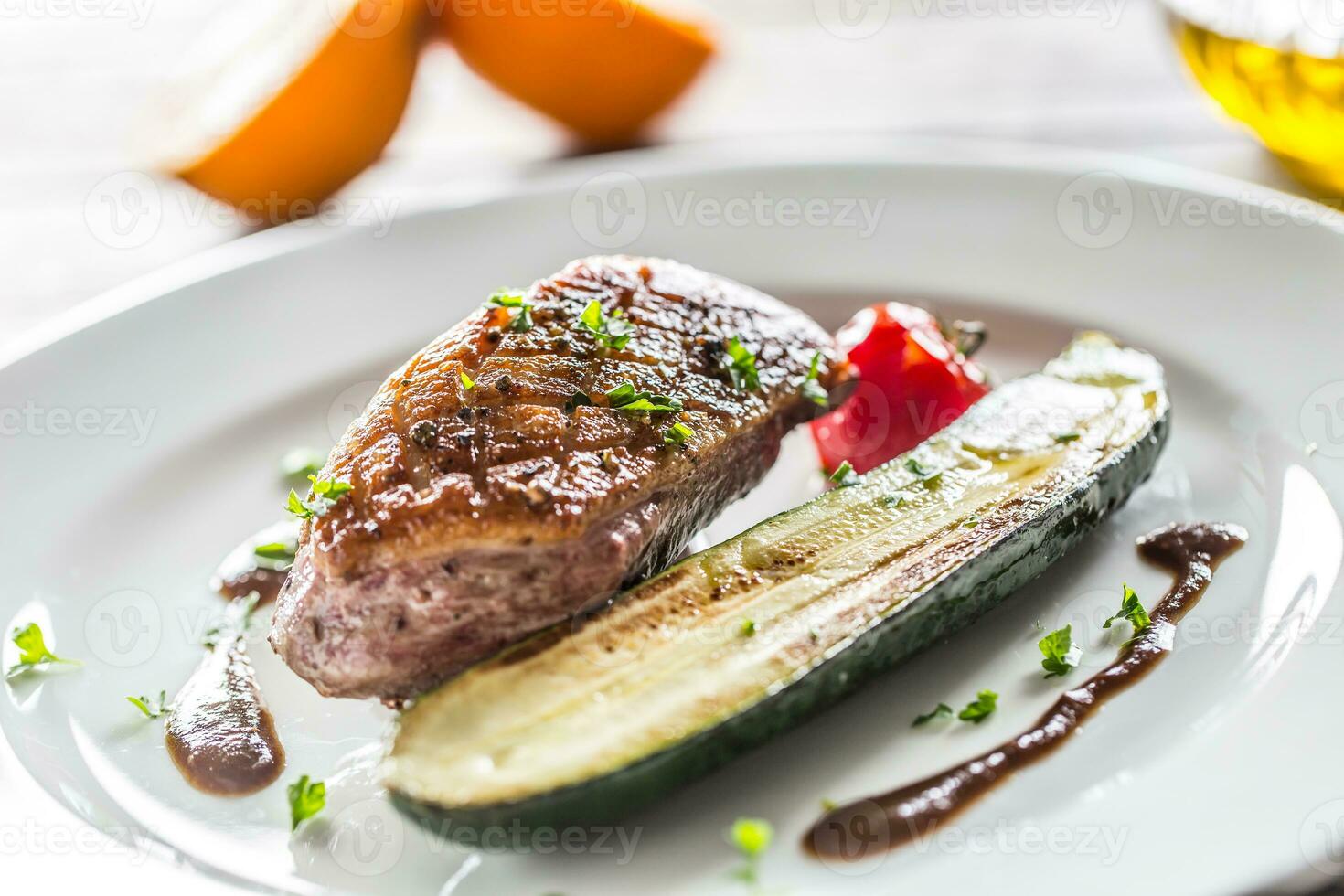 Roasted duck breast with zucchini tomato and parsley herbs photo