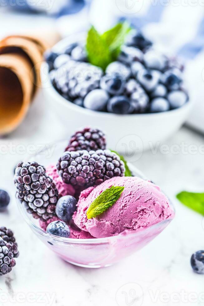 Blueberry and blackberry ice cream in bowl with frozen fruits photo