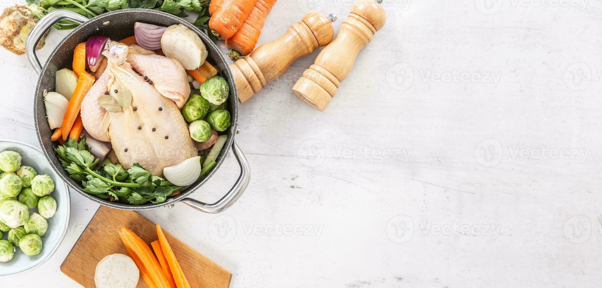 Chicken ready to cook broth with fresh root vegetables and spices photo