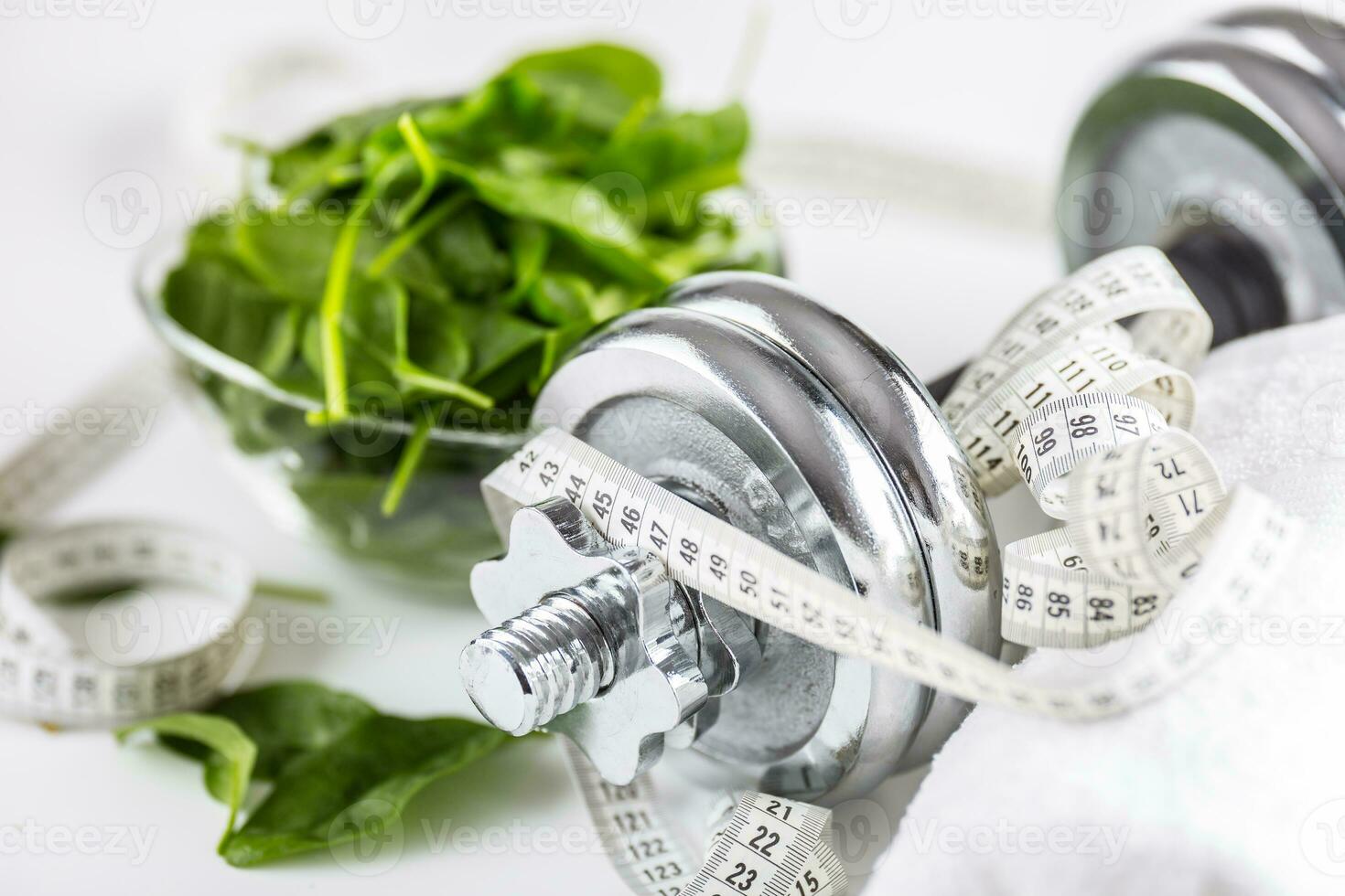 Spinach dumbbells and measure tape isolated on white background photo