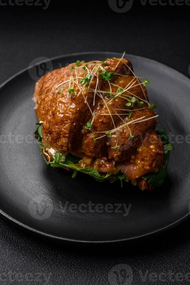 Delicious crispy croissant with salmon, lettuce, cheese and tomatoes photo