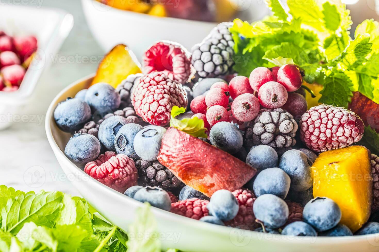 Frozen fruits blueberries blackberry raspberry red currant peach and herbs melissa photo