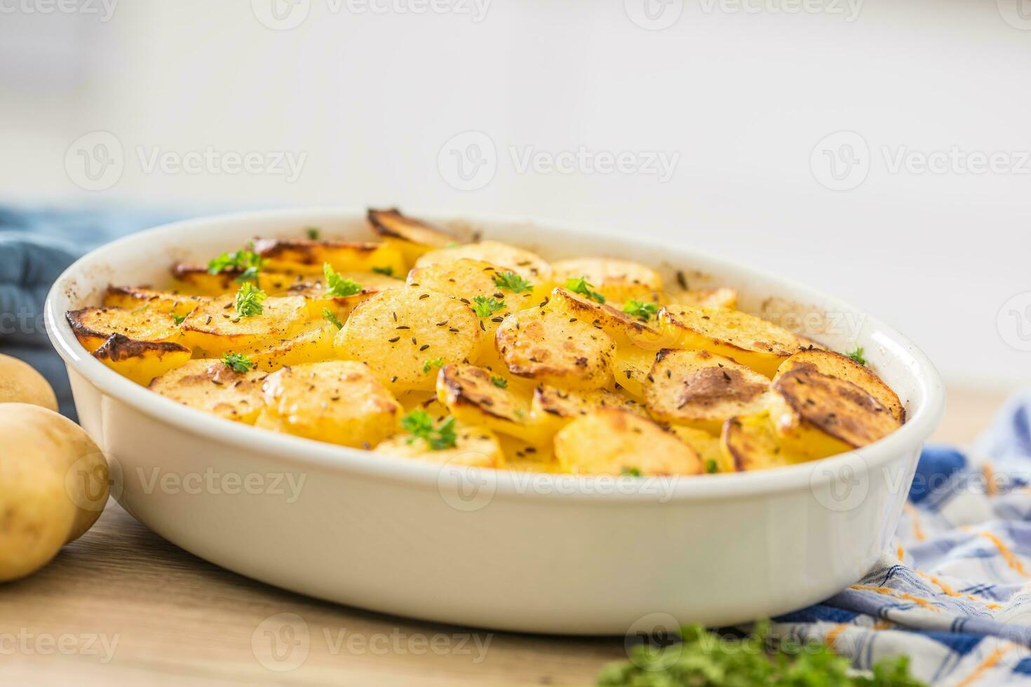 asado patatas con especias y hierbas en cocina mesa foto
