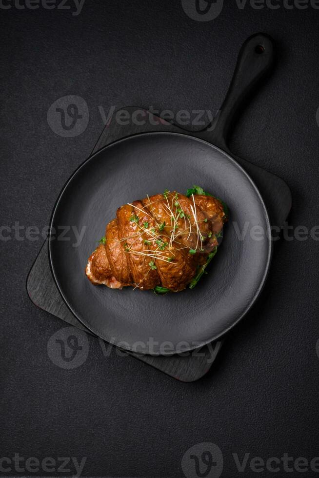 Delicious crispy croissant with salmon, lettuce, cheese and tomatoes photo