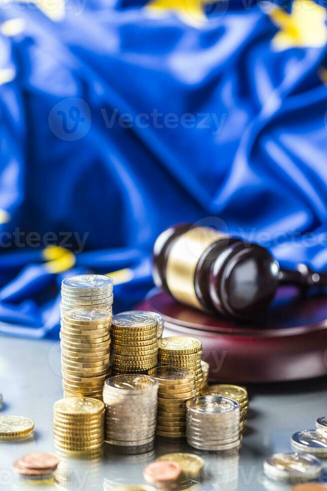 Towers with euro coins flag of European Union and justice hammer in the background photo