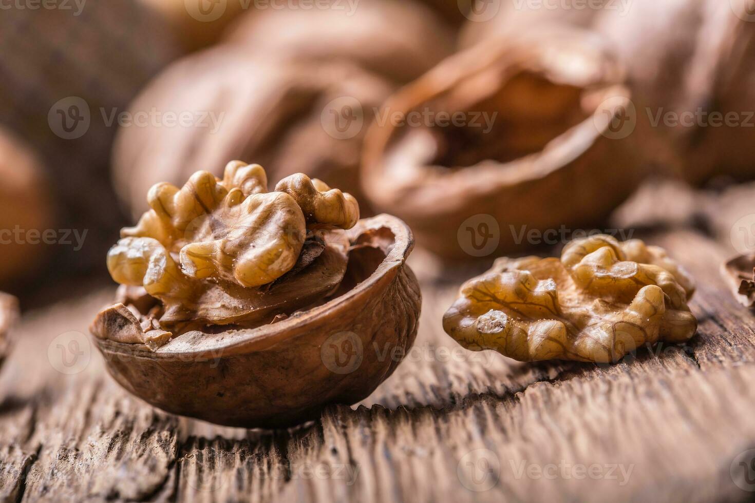 Walnut. Walnut kernels and whole walnuts on rustic old oak table photo