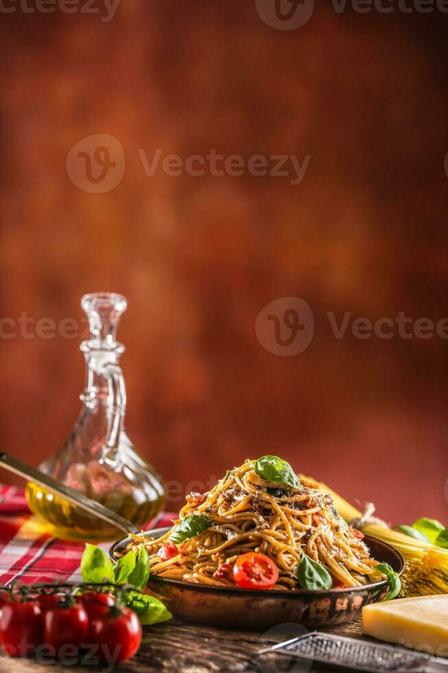 italiano pasta espaguetis con tomate salsa aceituna petróleo albahaca y parmesano queso en antiguo pan foto