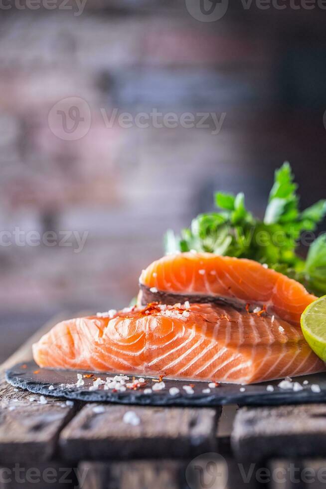 Raw salmon fillets with parsley herbs lime lemon salt and dried saffron photo