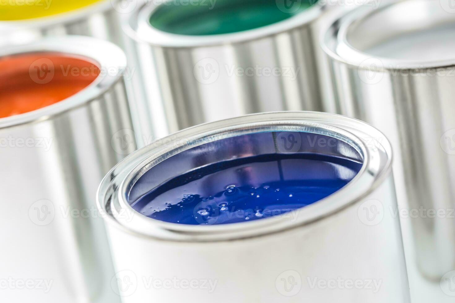 Full of multicolored paint cans on white table photo