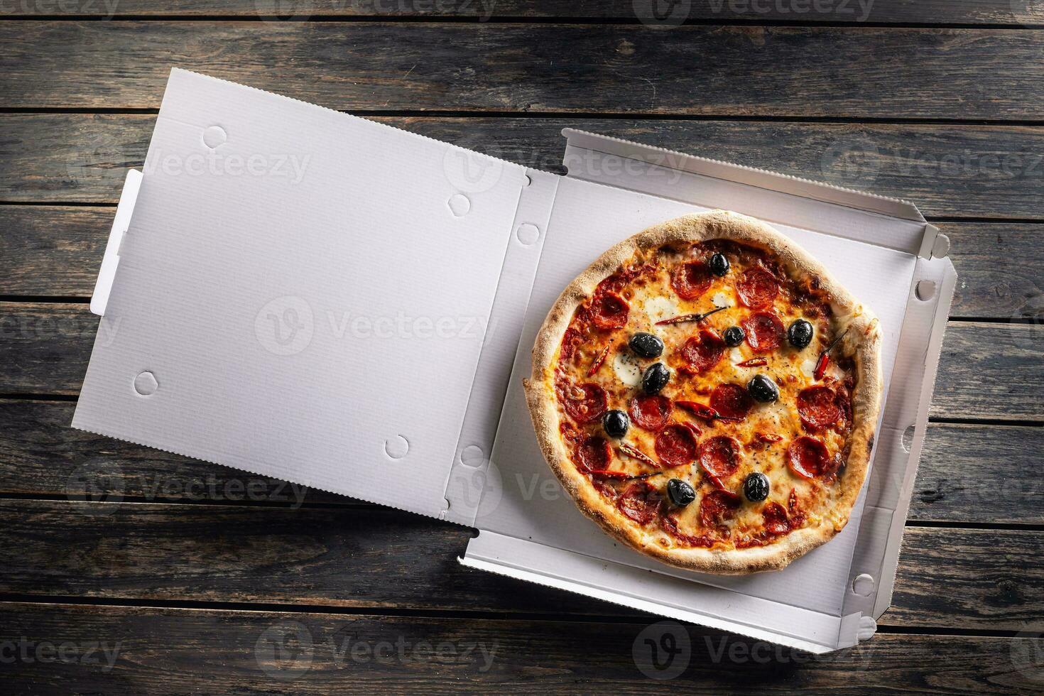 Pizza in a cardboard box on table ready to customer. photo