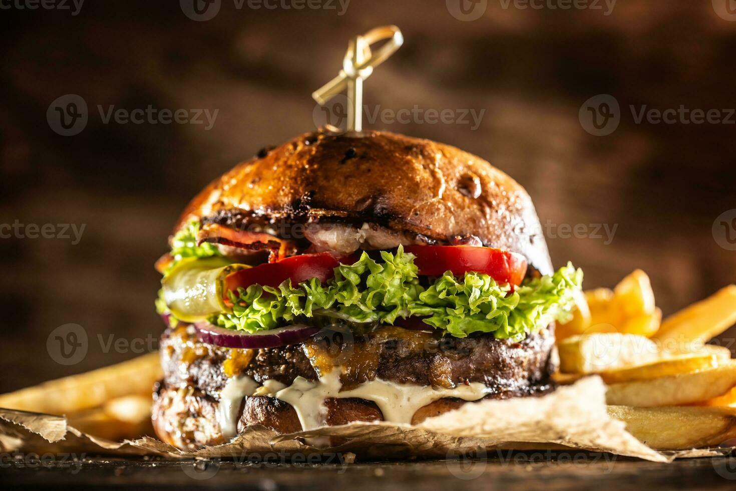 Classic beef burger with cheese cheddar bacon wegetable and french fries photo