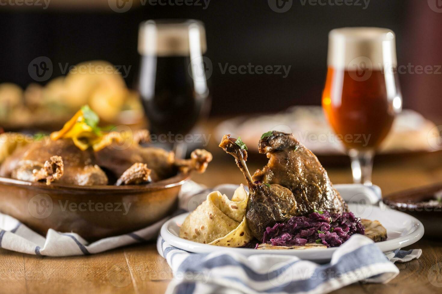 Roasted christmas duck leg red cabbage dumplings liver draft beer and baked buns photo