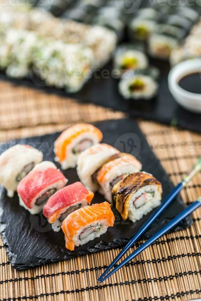 conjunto de rodar Sushi oro California con palillos y soja salsa. foto