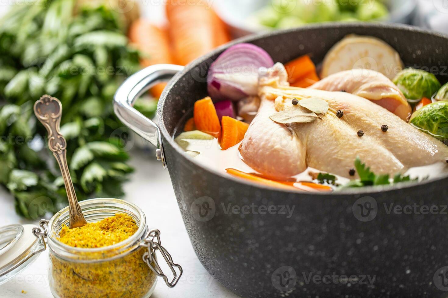Chicken ready to cook broth with fresh root vegetables and spices photo