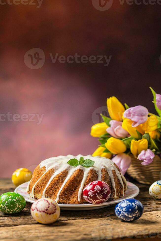 Easter Cake. Traditional ring marble cake withe easter decotation. Easter eggs and spring tulips. photo