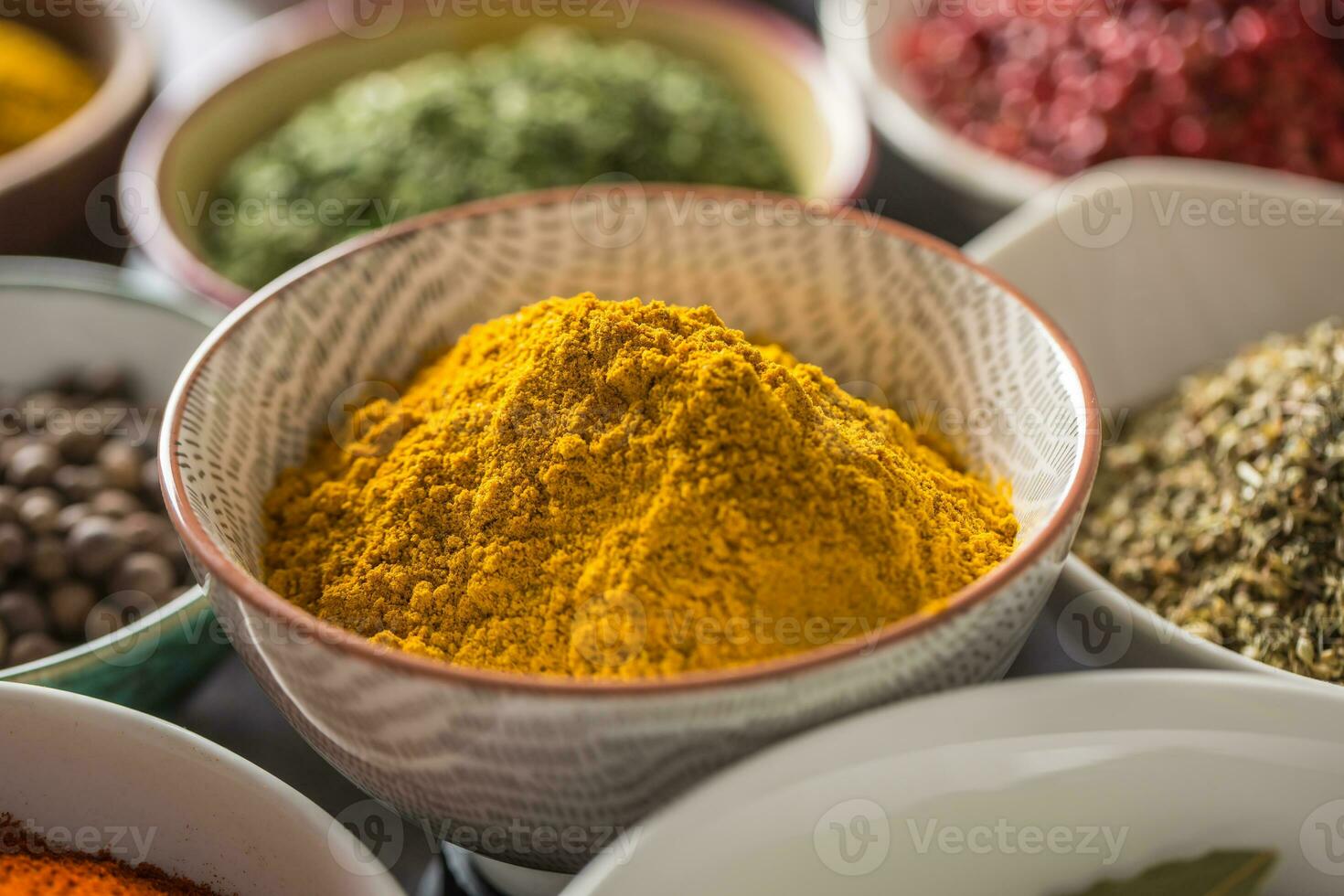Curry and variety spices and herbs in bowls photo