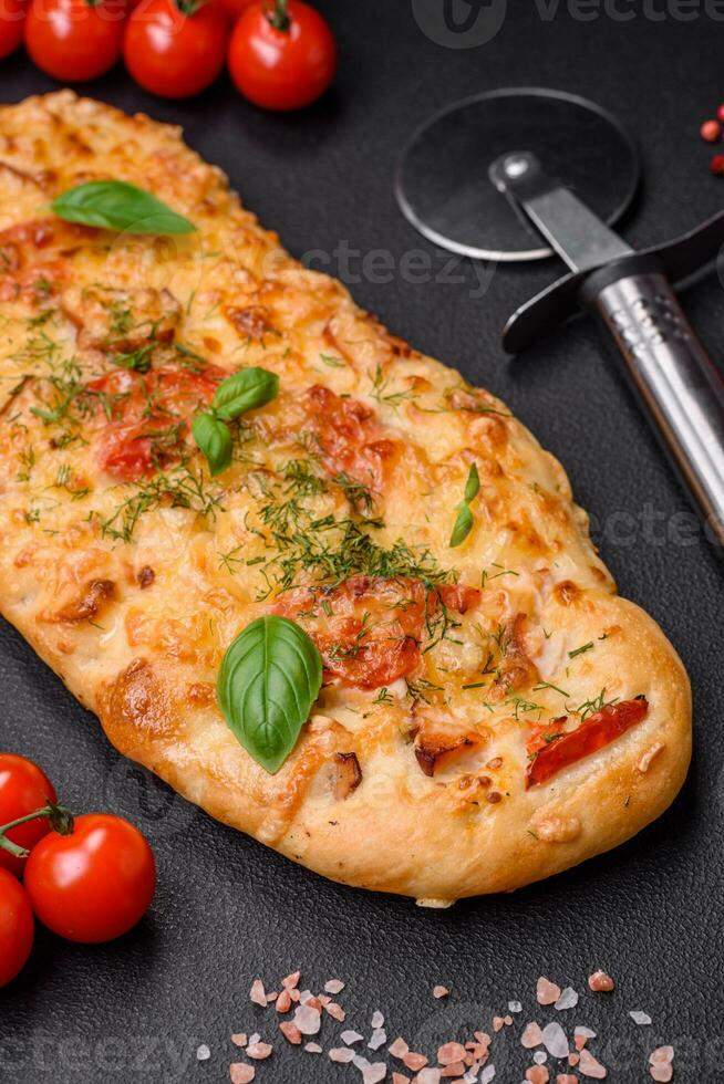 Delicious oven fresh flatbread pizza with cheese, tomatoes, sausage, salt and spices photo