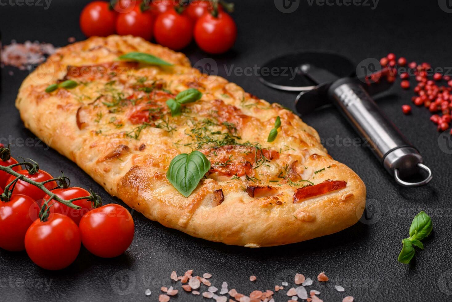 Delicious oven fresh flatbread pizza with cheese, tomatoes, sausage, salt and spices photo