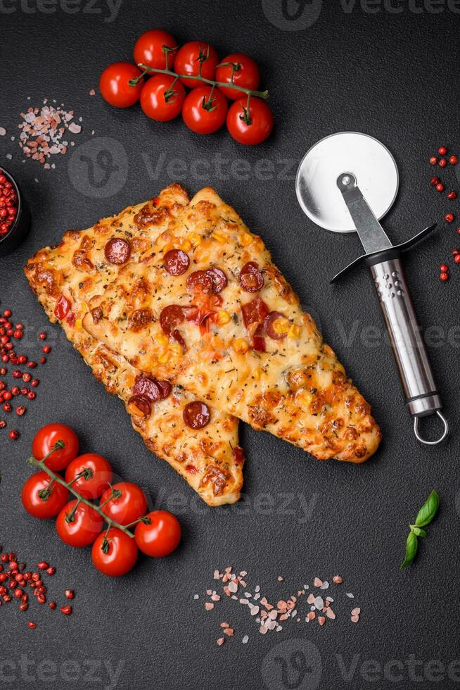 Delicious oven fresh flatbread pizza with cheese, tomatoes, sausage, salt and spices photo