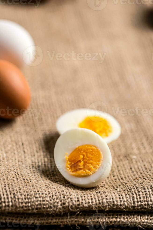 Close-up boiled or raw chicken eggs on wooden board photo