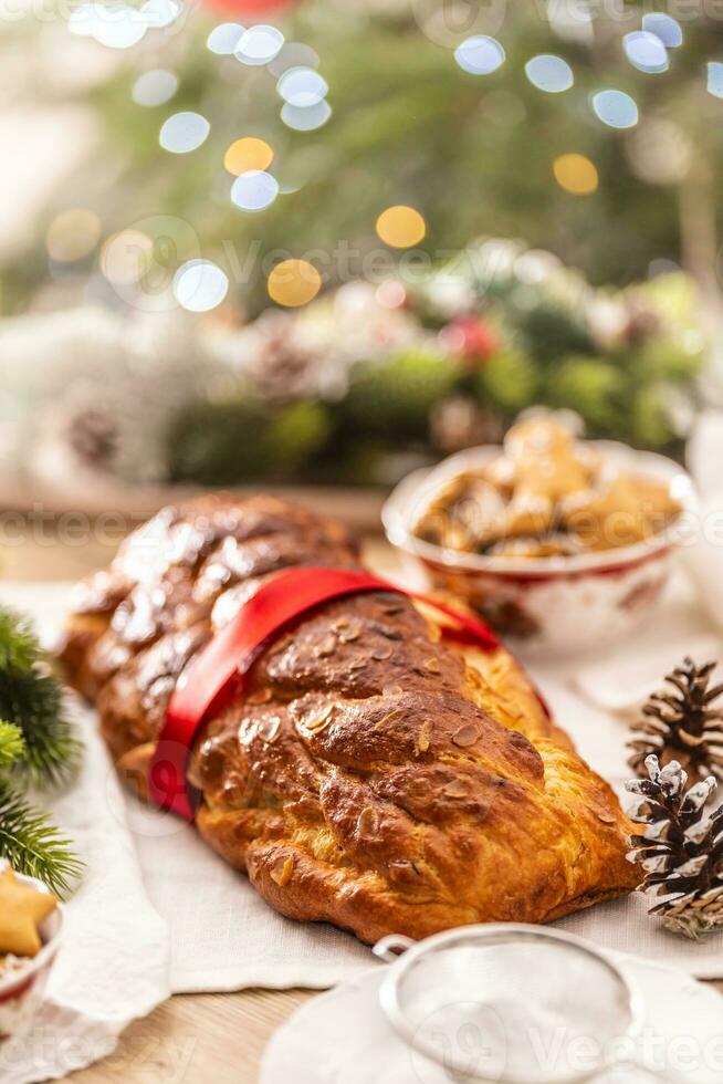 Traditional Czech Christmas cake Vanocka on a festive table in front of a Christmas tree photo