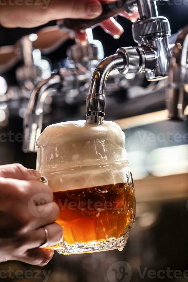 Mixing dark beer with light in one mug by tapping it from a tap, creating rich foam photo