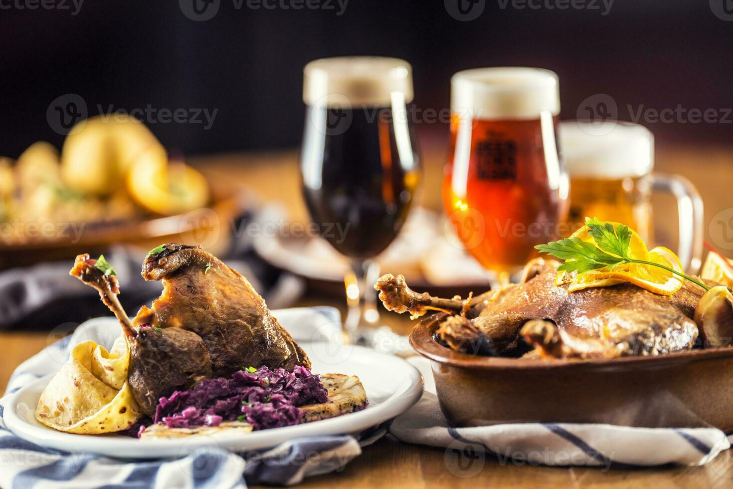 Roasted christmas duck leg red cabbage dumplings liver draft beer and baked buns photo