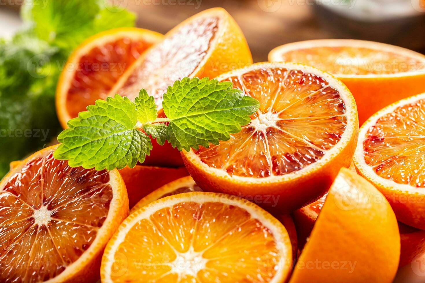 Blood sicilian oranges sliced with fresh melissa - close up photo