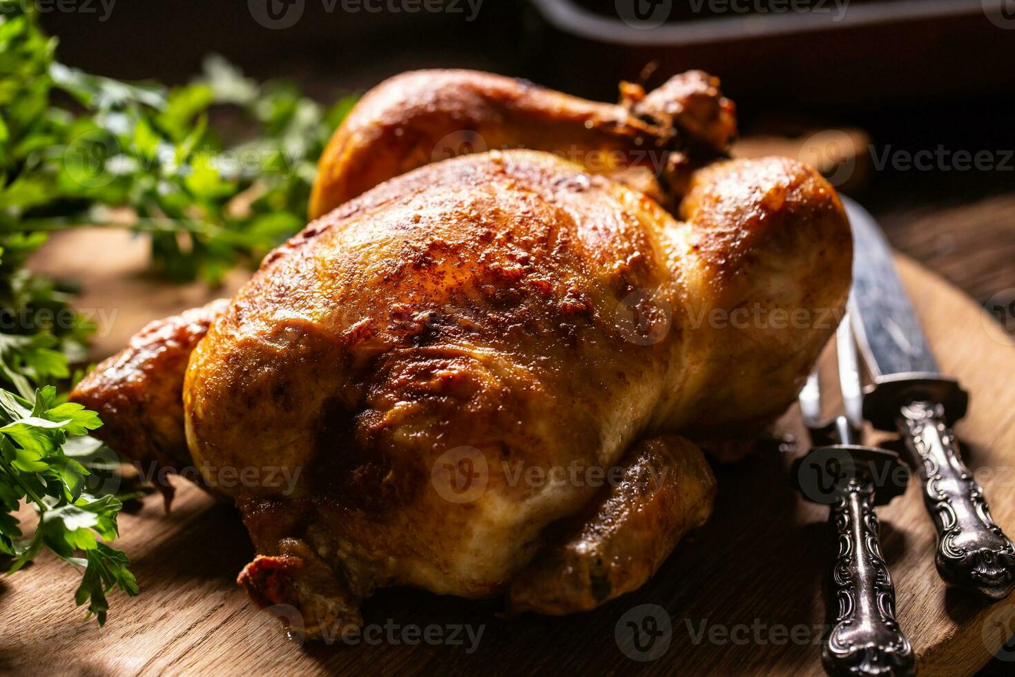 Roast chicken whole on a wooden cutting board photo