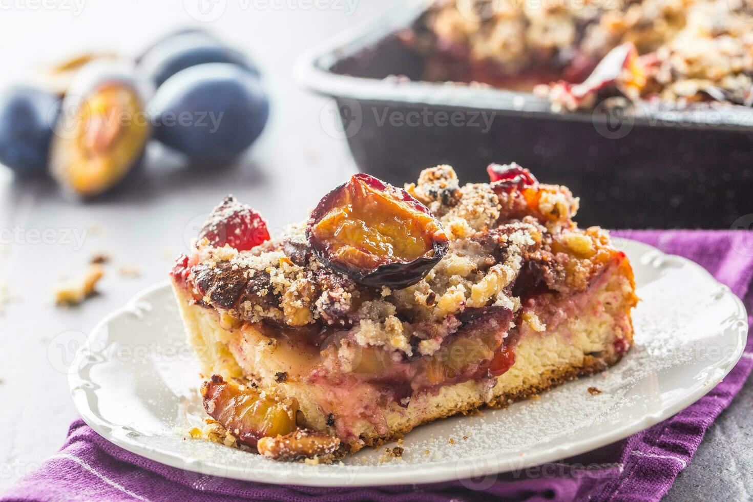 The traditional sweet plum cake on white plate photo