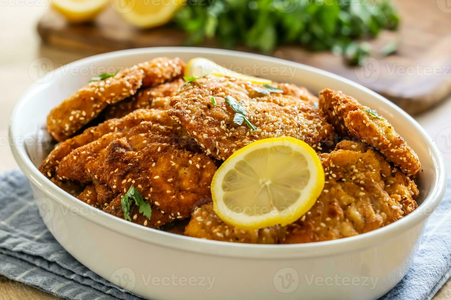 Juicy and crispy breaded meat as schnitzels are served with a slice of lemon photo