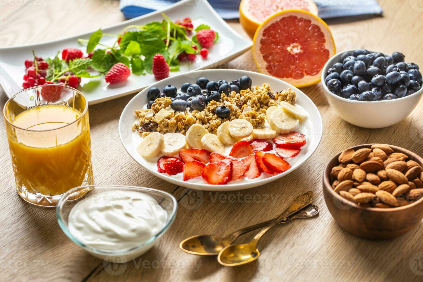 Healthy breakfast served with plate of yogurt muesli blueberries strawberries and banana. photo