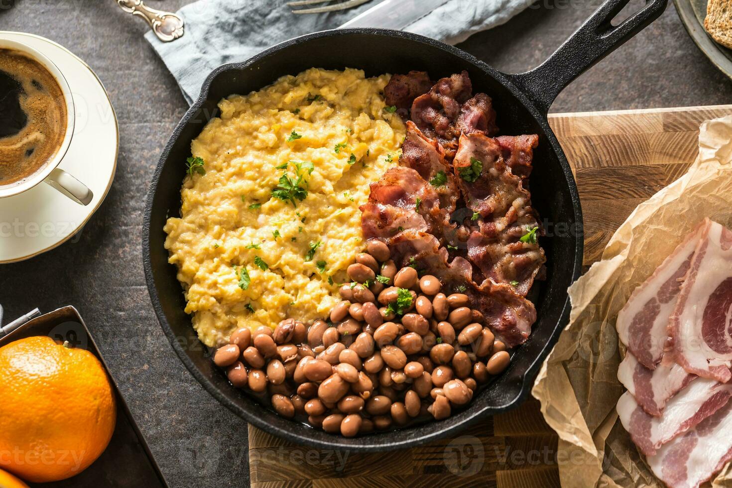 Full table of english breakfast. Scrambled eggs grilled bacon beans toast bread orange juice and coffee photo